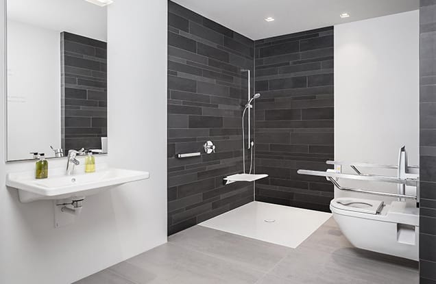 Salle de bain accessible avec douche à l'italienne et finitions bois